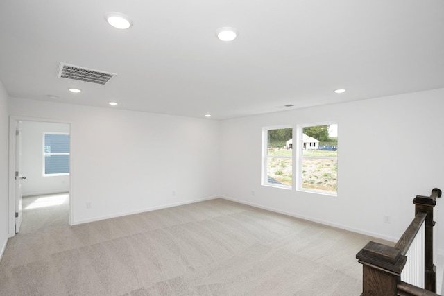 empty room featuring recessed lighting, visible vents, and light colored carpet