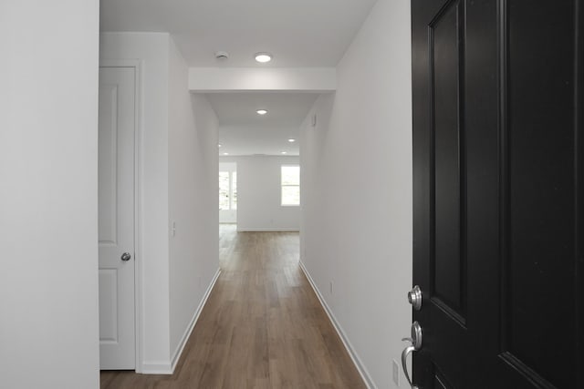 hall featuring recessed lighting, wood finished floors, and baseboards