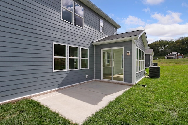 back of property featuring a yard, cooling unit, and a patio