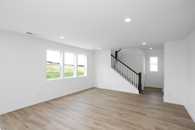 spare room featuring recessed lighting, visible vents, stairway, light wood-type flooring, and baseboards