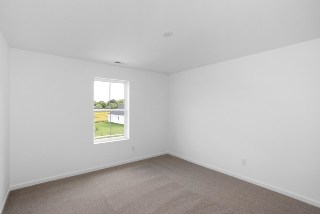 unfurnished room featuring carpet, visible vents, and baseboards