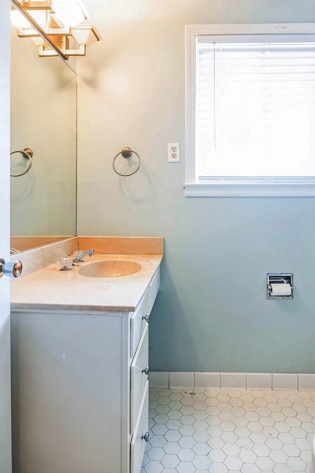 bathroom with vanity, baseboards, and tile patterned floors