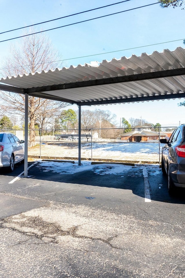 covered parking lot featuring fence