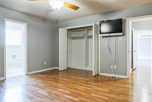 unfurnished bedroom featuring light wood-style flooring, baseboards, a closet, and ensuite bathroom