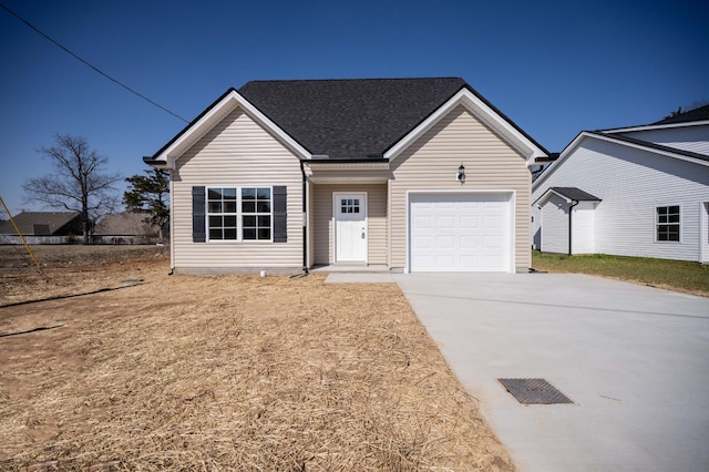 view of front of home featuring a garage, driveway, and a shingled roof