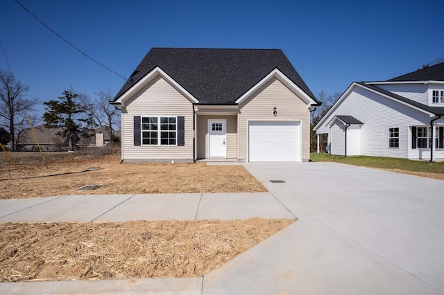 view of front facade featuring driveway, an attached garage, and a shingled roof