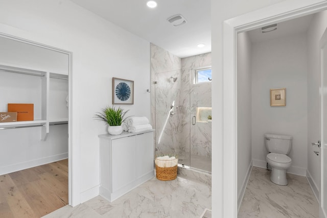 bathroom featuring marble finish floor, a marble finish shower, visible vents, toilet, and baseboards