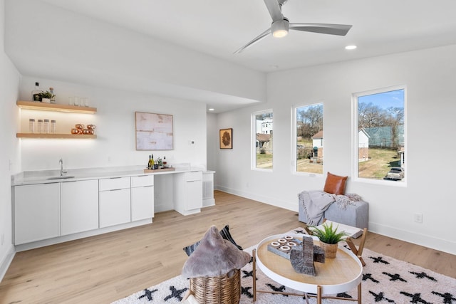 interior space featuring light wood-type flooring, baseboards, indoor wet bar, and recessed lighting