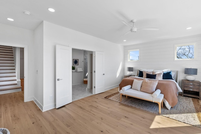 bedroom featuring baseboards, ensuite bath, light wood-style flooring, and recessed lighting