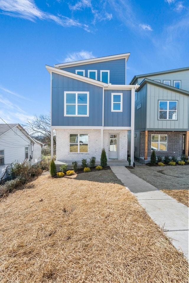 view of front of home featuring brick siding and board and batten siding