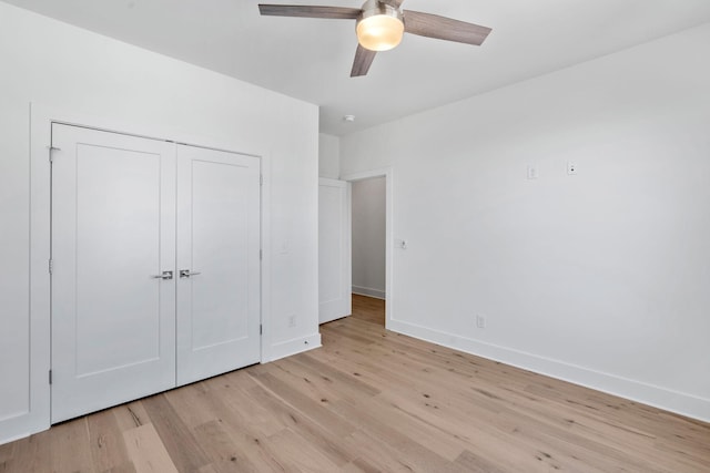 unfurnished bedroom with light wood-style floors, a ceiling fan, baseboards, and a closet