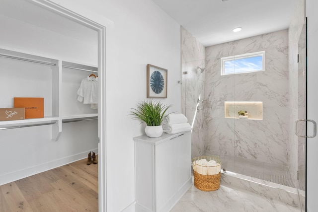 full bathroom featuring a marble finish shower, baseboards, wood finished floors, and recessed lighting