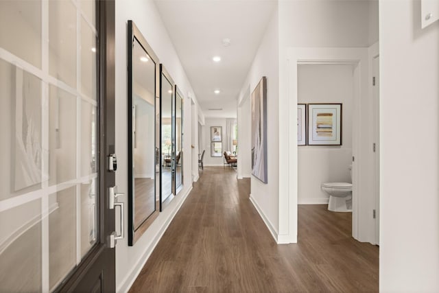 corridor featuring dark wood-style floors, recessed lighting, and baseboards