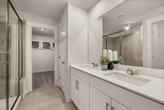 bathroom featuring a stall shower, a sink, and visible vents