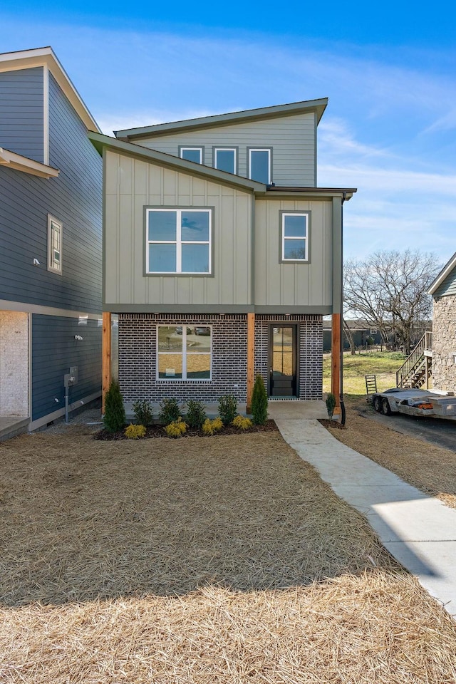 view of front of property featuring board and batten siding and brick siding