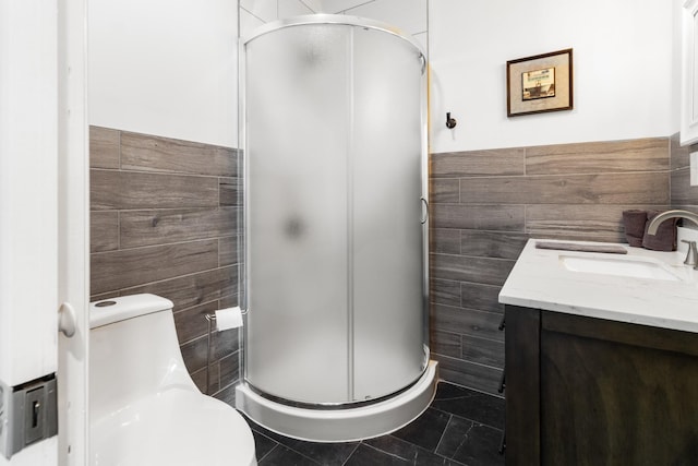 full bath featuring toilet, a stall shower, and tile walls