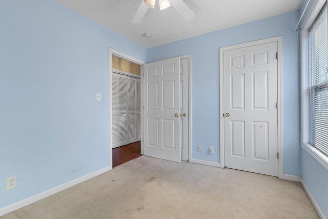 unfurnished bedroom with light carpet, baseboards, and multiple windows