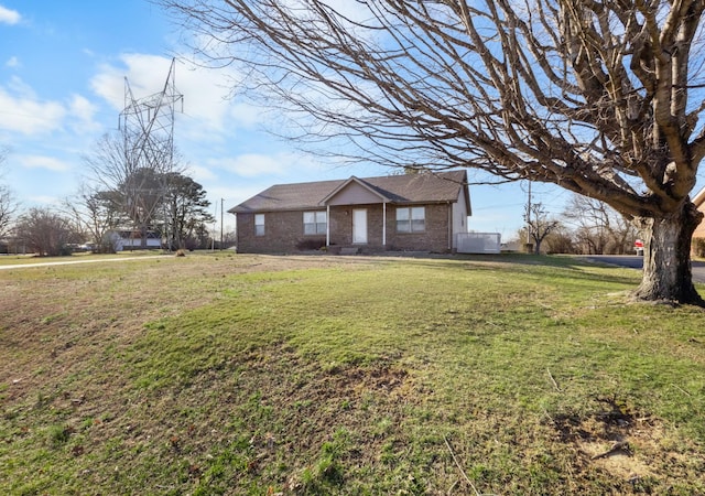 single story home with brick siding and a front yard