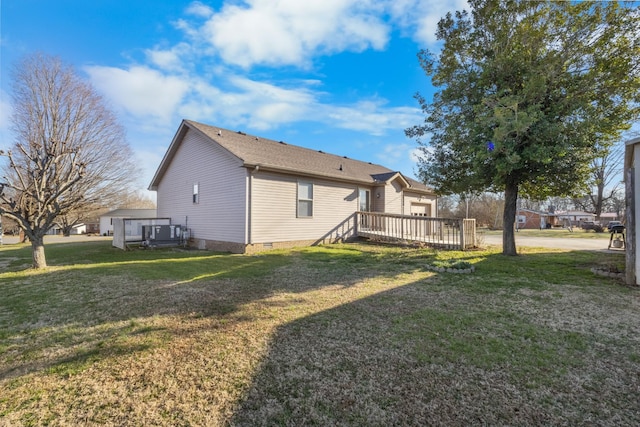 rear view of property with a yard, an attached garage, crawl space, a deck, and cooling unit