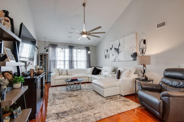 living area with a wealth of natural light, wood finished floors, visible vents, and a ceiling fan