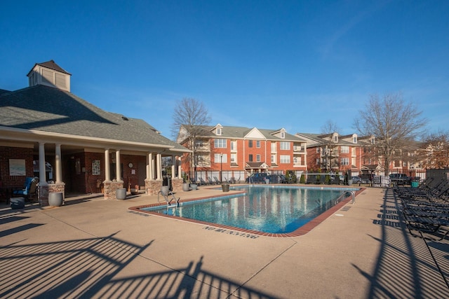 pool featuring a residential view, a patio area, and fence