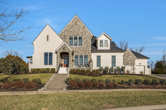 view of front of home featuring stone siding, brick siding, and a front yard