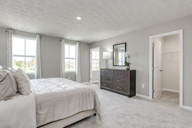 bedroom with multiple windows, baseboards, and light colored carpet