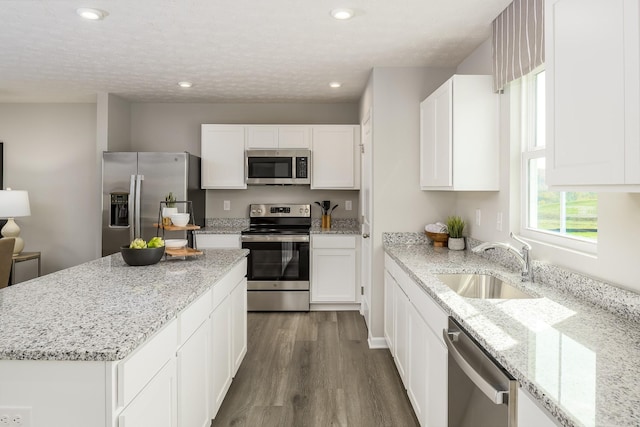 kitchen with white cabinetry, appliances with stainless steel finishes, dark wood finished floors, and a sink