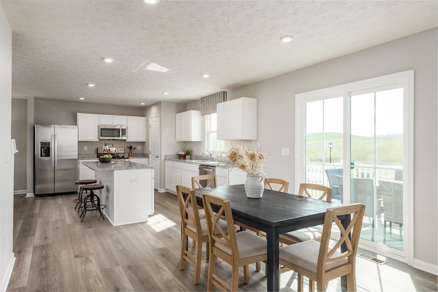 dining area featuring light wood-style floors, a wealth of natural light, visible vents, and recessed lighting