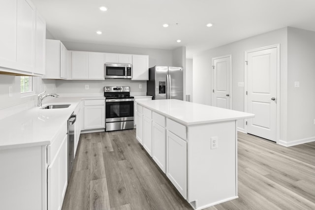 kitchen featuring light wood-style flooring, recessed lighting, stainless steel appliances, a sink, and a center island