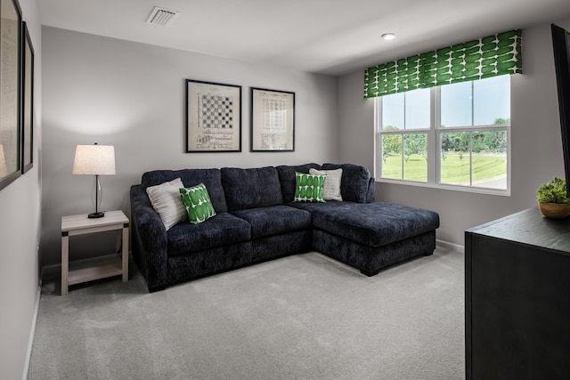 living room with carpet, visible vents, and baseboards