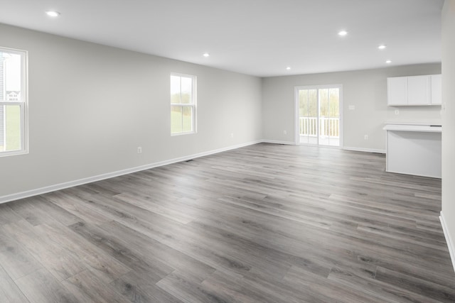 unfurnished living room featuring recessed lighting, baseboards, and wood finished floors