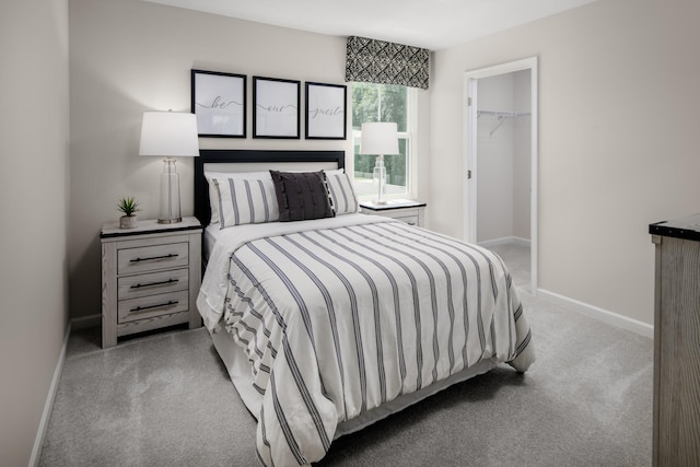 bedroom with carpet, a spacious closet, baseboards, and a closet