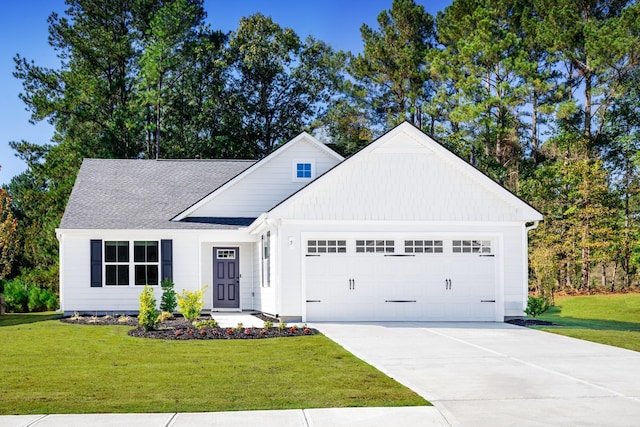 view of front of property with a garage, driveway, a front lawn, and roof with shingles