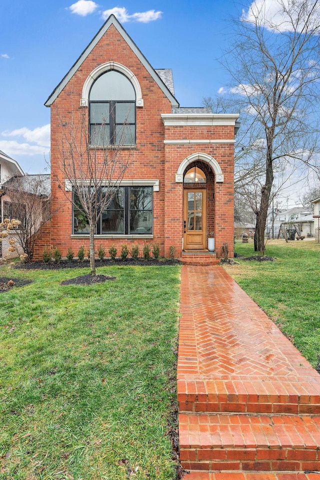 traditional home with a front yard and brick siding