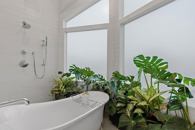 bathroom with a freestanding tub and tiled shower