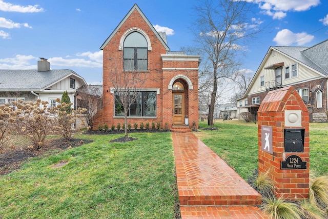 traditional-style house featuring brick siding and a front lawn