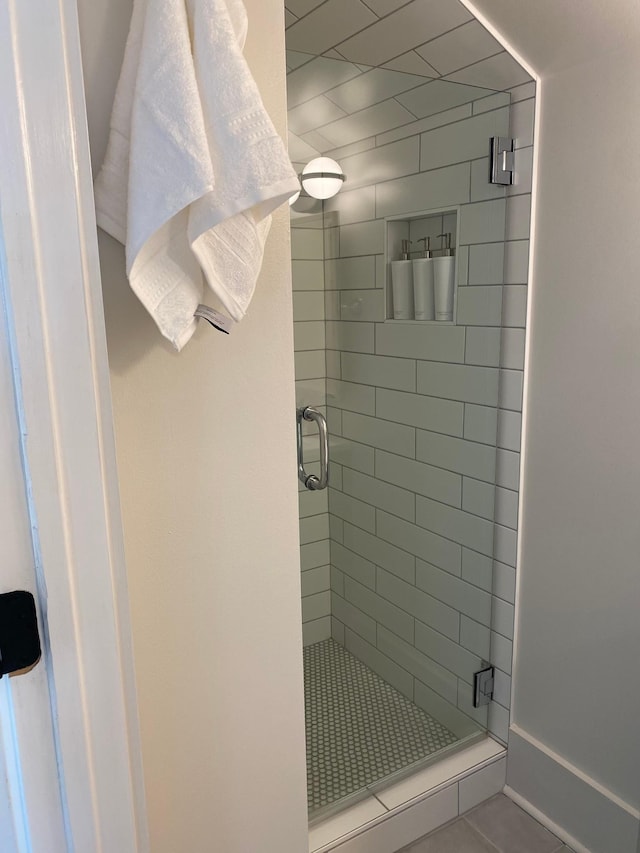 full bathroom featuring a stall shower and baseboards