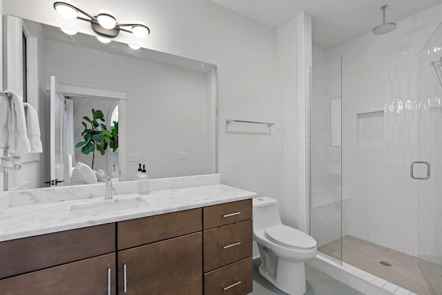 full bath with ensuite bathroom, a stall shower, vanity, and toilet