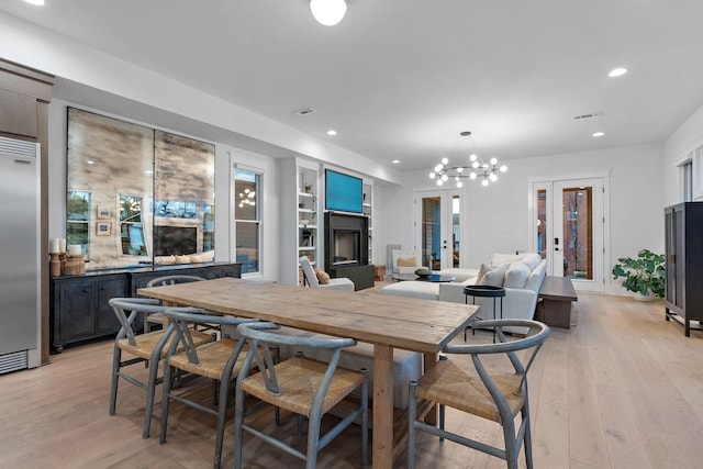 dining space featuring wine cooler, recessed lighting, a fireplace, light wood-style floors, and french doors