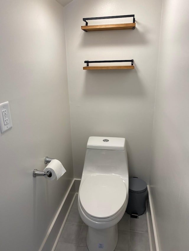 bathroom with baseboards, toilet, and tile patterned floors