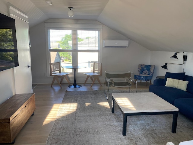 living room featuring a wall mounted air conditioner, vaulted ceiling, baseboards, and wood finished floors