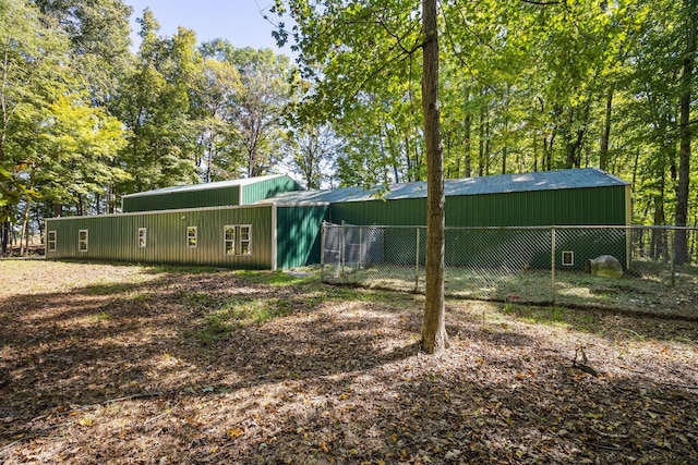 exterior space featuring a pole building, an outdoor structure, and fence