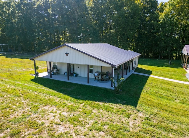 view of front of property with a patio area, metal roof, and a front lawn