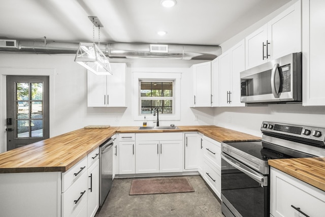 kitchen featuring visible vents, wood counters, appliances with stainless steel finishes, and a sink