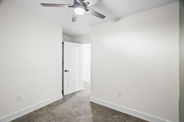 empty room featuring dark carpet, a ceiling fan, and baseboards