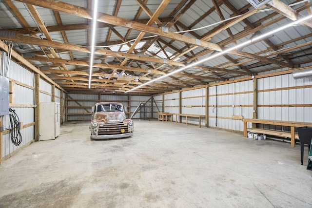 garage featuring metal wall and freestanding refrigerator