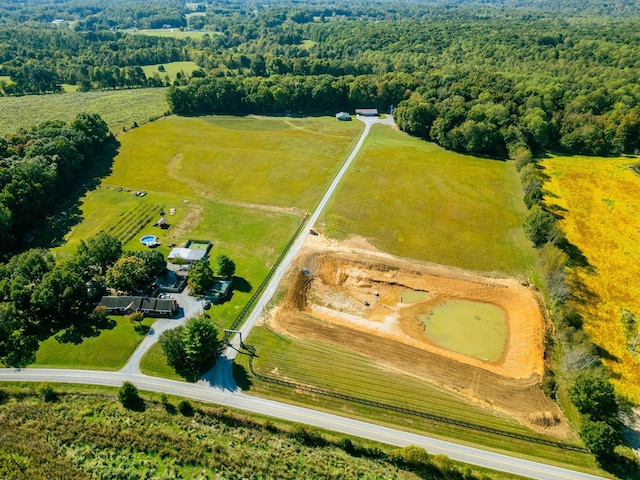 birds eye view of property featuring a wooded view and a rural view