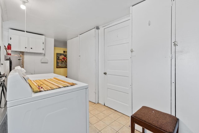 laundry area with water heater, cabinet space, separate washer and dryer, and light tile patterned floors