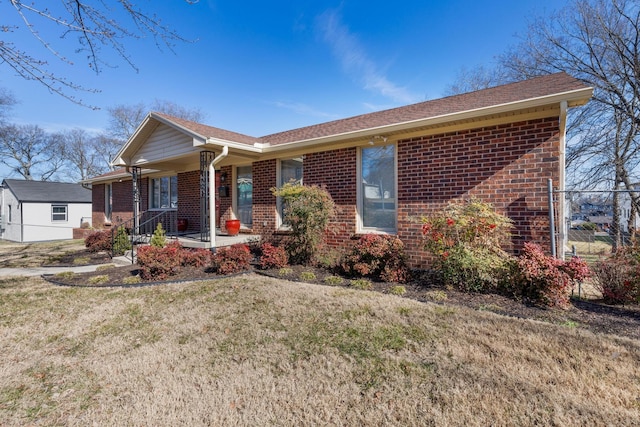 single story home featuring covered porch, brick siding, and a front lawn